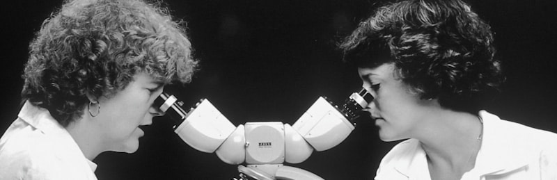 doctors looking through a microscope analyzing MIGS procedures