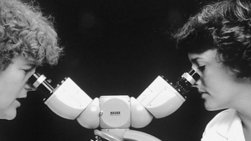 doctors looking through a microscope analyzing MIGS procedures